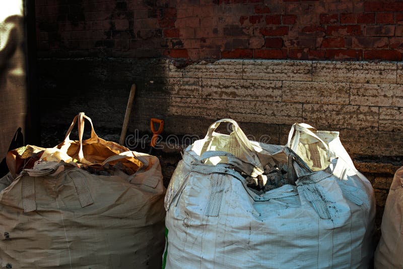 Industrial Construction Garbage in Bags Against a Brick Wall Stock