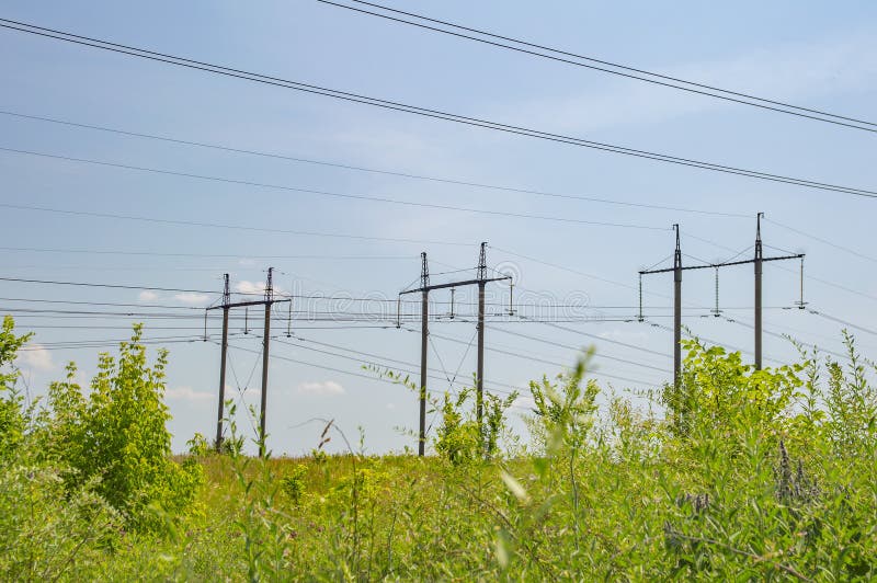 Industrial landscape - high-voltage power transmission line against a blue sky royalty free stock photo Industrial landscape - high-voltage power transmission line against a blue sky royalty free stock photo