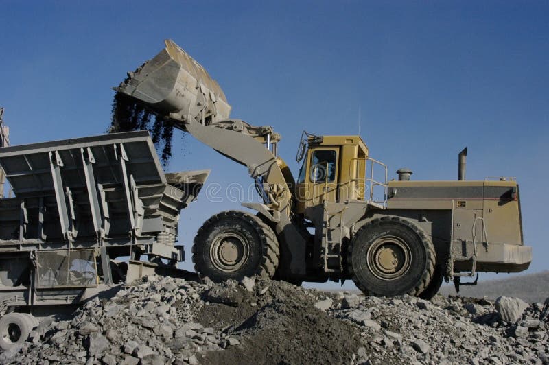 Industrial loader dumping aggregates in crusher
