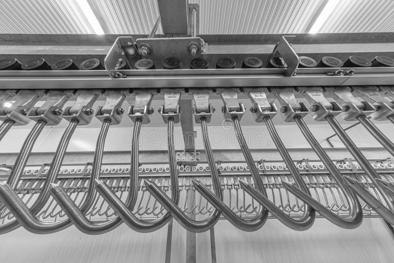 Industrial loading dock area inside cold storage warehouse. Meat hanging hooks hanging on the rail system royalty free stock photos