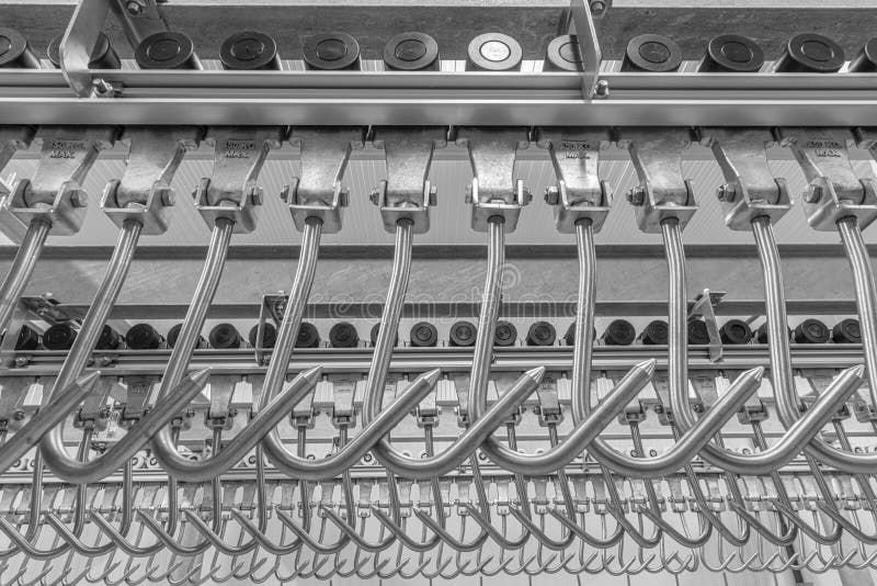 Industrial loading dock area inside cold storage warehouse. Meat hanging hooks hanging on the rail system royalty free stock photography