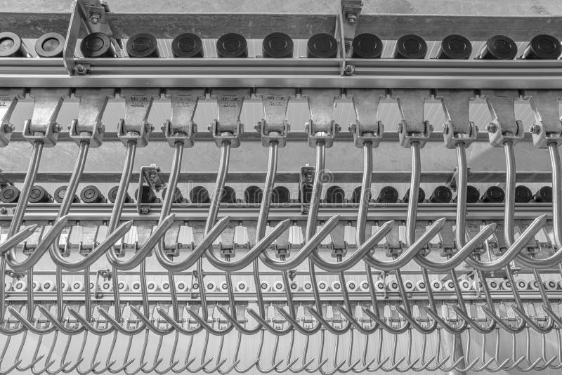 Industrial loading dock area inside cold storage warehouse. Meat hanging hooks hanging on the rail system royalty free stock photos