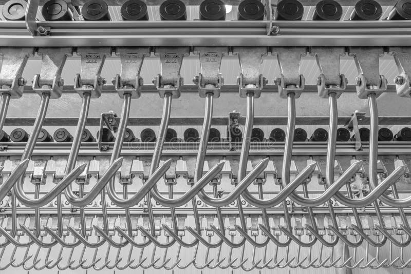 Industrial loading dock area inside cold storage warehouse. Meat hanging hooks hanging on the rail system stock photo