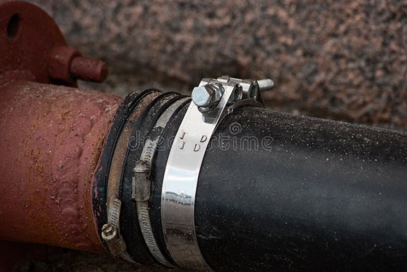 Industrial plastic pipe wrapped around a metal hose clamp