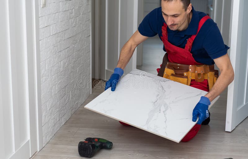 Industrial Tiler Builder Worker Installing Floor Tile at Repair Renovation Work Stock Image
