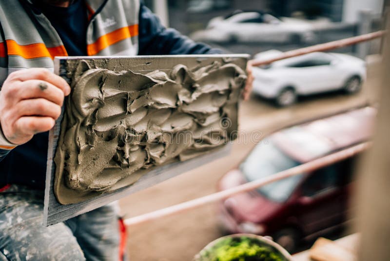 Industrial worker placing marble stone with adhesive on architecture facade on construction site. People on building site. Bricklayer tiler stock images, royalty-free photos and pictures