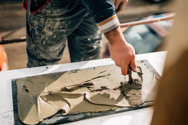 Industrial worker using trowel and tools for building exterior walls with stone and mortar and adhesive. Bricklayer tiler stock images, royalty-free photos and pictures