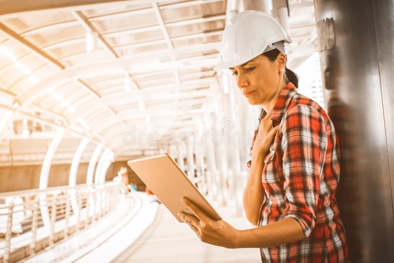 Industriebauingenieur-Abnutzungsschutzhelmtechnik, die digitale Tablette auf Gebäudeaußenseite bearbeitet und verwendet lizenzfreies stockfoto Industriebauingenieur-Abnutzungsschutzhelmtechnik, die digitale Tablette auf Gebäudeaußenseite bearbeitet und verwendet lizenzfreies stockfoto
