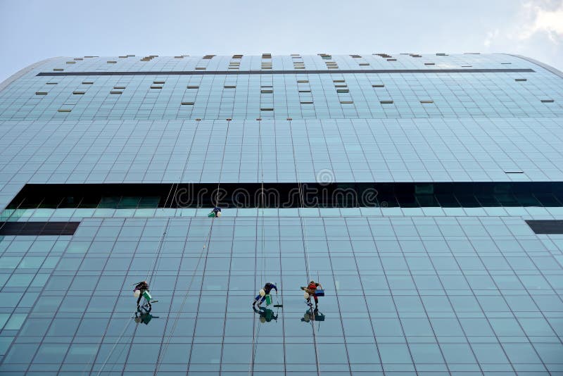 Industrieklettererwäschen Glas auf der Fassade eines Wolkenkratzers stockfoto Industrieklettererwäschen Glas auf der Fassade eines Wolkenkratzers stockfoto