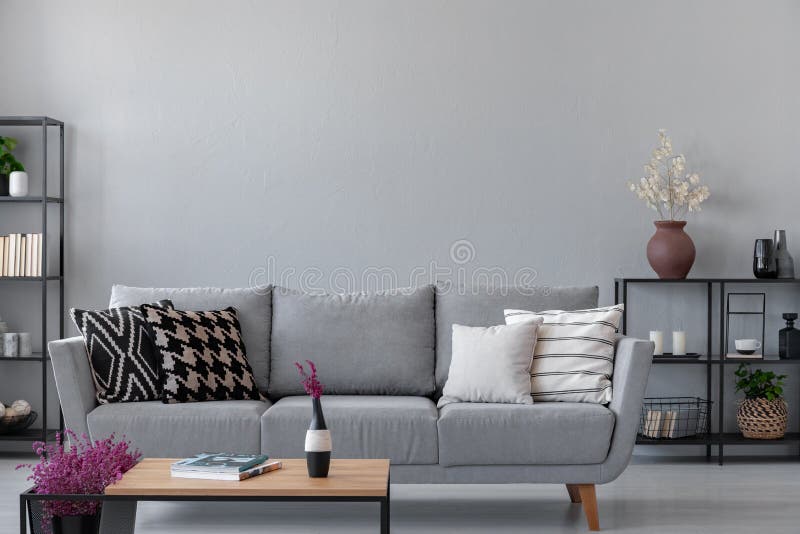 Industrial living room with simple grey sofa and metal furniture, real photo with copy space on the wall. Industrial living room with simple grey sofa and metal furniture, real photo with copy space on the wall