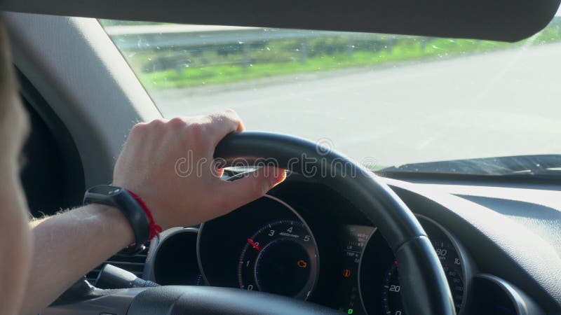 Inside a Car. A Man`s Hands on the Steering Wheel. Gray, lane.