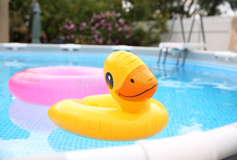Inele gonflabile plutind pe apă în piscina deasupra solului în aer liber royalty free stock photography