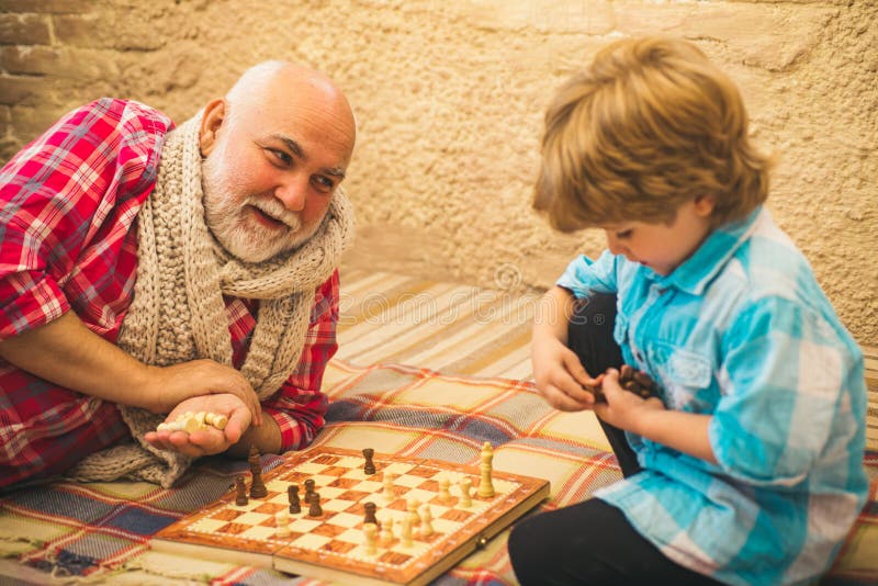 Infância. Sênior Ensinando Seu Neto a Jogar Xadrez. Criança