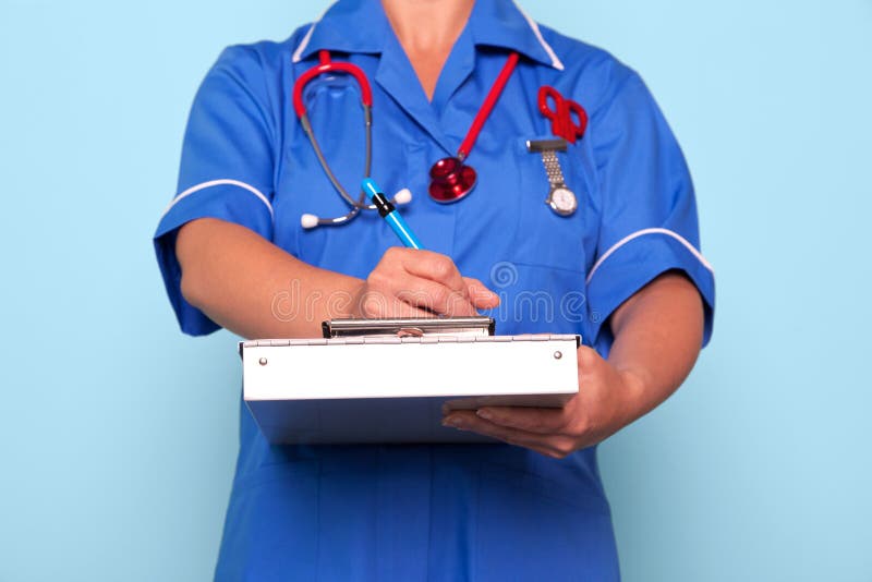 Infermiera che scrive un rapporto medico immagini stock Infermiera che scrive un rapporto medico immagini stock