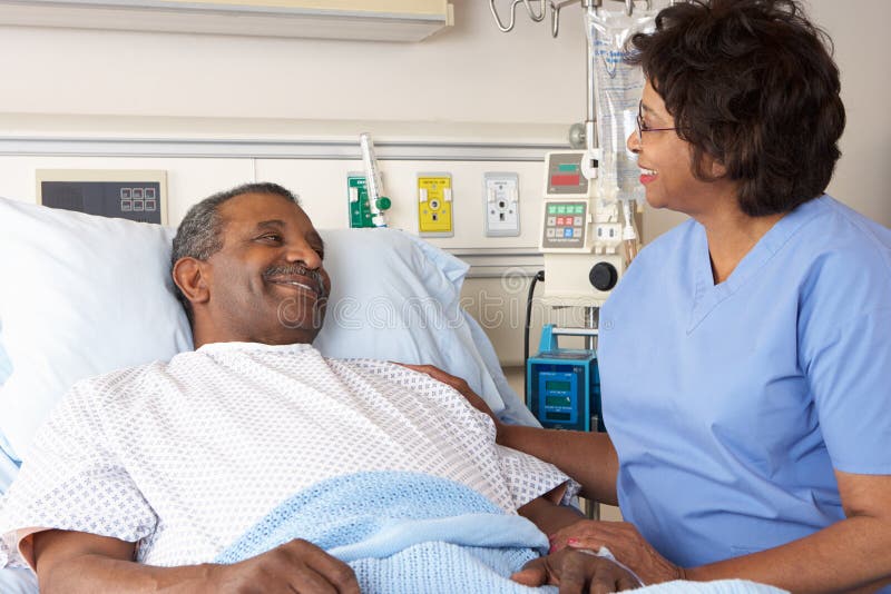 Nurse Talking To Senior Male Patient On Ward Smiling. Nurse Talking To Senior Male Patient On Ward Smiling