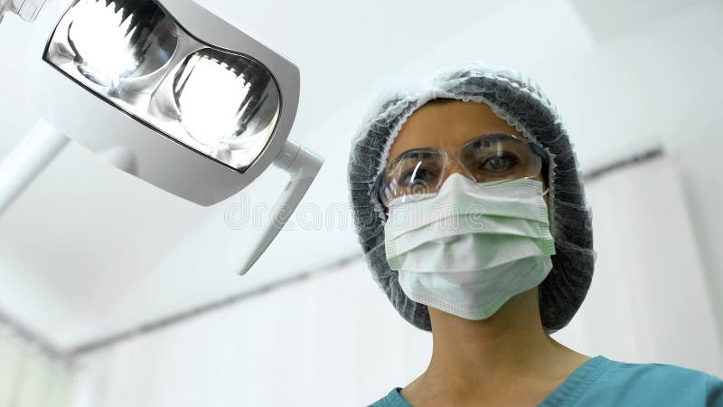 Infermiere femminile della chirurgia che esamina paziente, preparante per la procedura medica immagini stock Infermiere femminile della chirurgia che esamina paziente, preparante per la procedura medica immagini stock