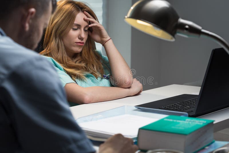 Infermiere sovraccarico che si siede allo scrittorio immagini stock libere da diritti Infermiere sovraccarico che si siede allo scrittorio immagini stock libere da diritti