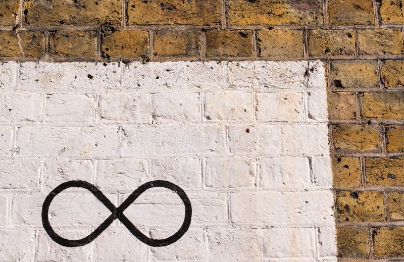 The infinity symbol drawn in black on a brick wall stock photos