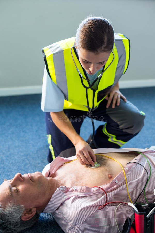 Infirmier examinant un patient pendant la réanimation cardio-respiratoire images stock Infirmier examinant un patient pendant la réanimation cardio-respiratoire images stock