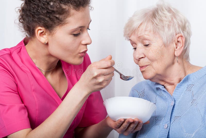 Infirmière alimentant une dame plus âgée