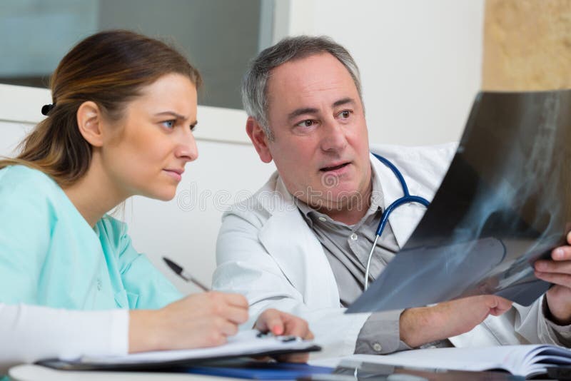 Infirmi?re et docteur regardant le rayon X photo libre de droits Infirmi?re et docteur regardant le rayon X photo libre de droits