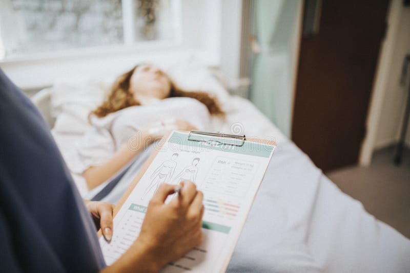 Infirmière notant en bas de l'information médicale de patients photo libre de droits