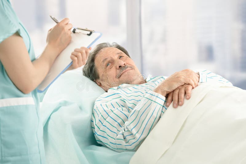 Infirmière prenant des notes de vieux patient images stock Infirmière prenant des notes de vieux patient images stock