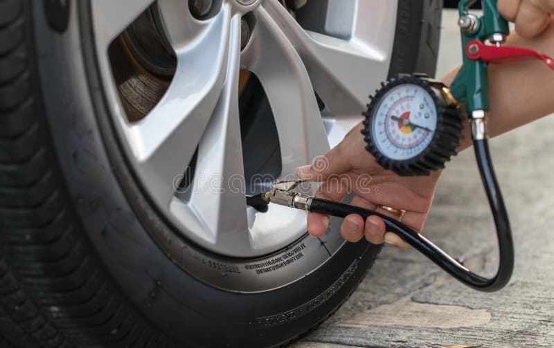 Inflating Car Tires with an Air Pump with a Pressure Gauge Stock Photo