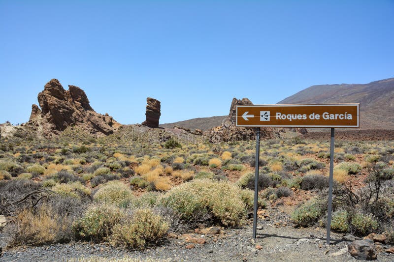 Information sign from the bizarrely shaped Roque Cinchado rock of volcanic rock in Teide National Park on the Canary Island of Tenerife, Spain. With blue skies. Information sign from the bizarrely shaped Roque Cinchado rock of volcanic rock in Teide National Park on the Canary Island of Tenerife, Spain. With blue skies