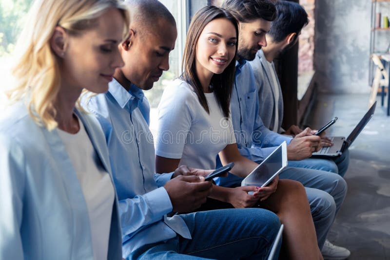 Informação realmente boa Grupo de jovens que sentam-se na conferência junto e no sorriso imagem de stock royalty free Informação realmente boa Grupo de jovens que sentam-se na conferência junto e no sorriso imagem de stock royalty free