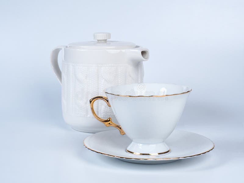 Infuser teapot with tea cup on white background.