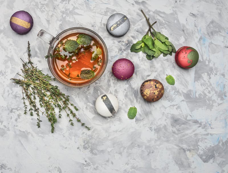 Infusión de hierbas caliente con la menta, el comino y los macarrones apetitosos frescos, en el fondo rústico blanco, visión supe imagen de archivo libre de regalías Infusión de hierbas caliente con la menta, el comino y los macarrones apetitosos frescos, en el fondo rústico blanco, visión supe imagen de archivo libre de regalías
