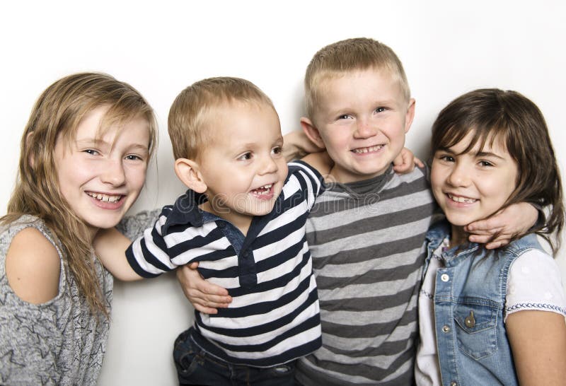 Infância, amor, felicidade e ligações de família Retrato interno de irmãs e do irmão bonitos bonitos das crianças imagem de stock Infância, amor, felicidade e ligações de família Retrato interno de irmãs e do irmão bonitos bonitos das crianças imagem de stock
