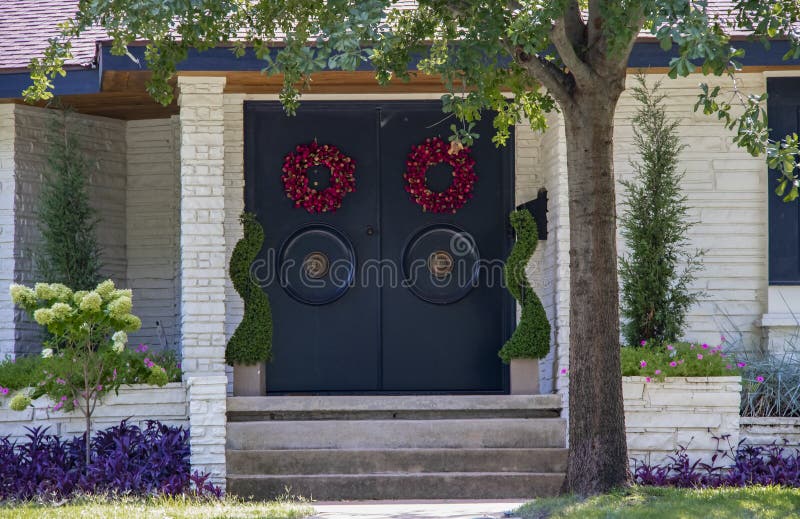Ingang van een wit steenhuis voor de betere inkomstklasse met Aziatische stijldeuren met grote ronde handvatten en rode kronen en royalty-vrije stock foto Ingang van een wit steenhuis voor de betere inkomstklasse met Aziatische stijldeuren met grote ronde handvatten en rode kronen en royalty-vrije stock foto