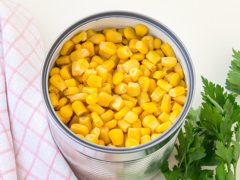 Ingeblikte suikermaïs in een blik en peterselie op een tafel Zijschaal en ingrediënt van salades Vegetinair voedsel royalty-vrije stock foto's Ingeblikte suikermaïs in een blik en peterselie op een tafel Zijschaal en ingrediënt van salades Vegetinair voedsel royalty-vrije stock foto's