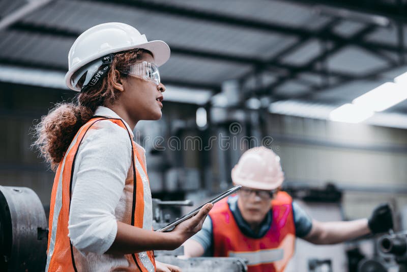 Ingeniera industrial femenina usando casco blanco mientras
