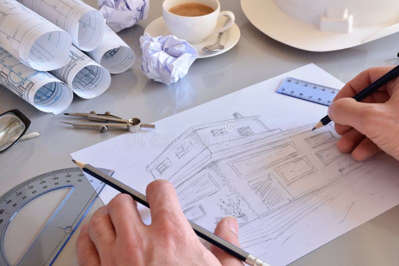 Ingeniero de construcción que dibuja una casa en su escritorio de oficina fotografía de archivo libre de regalías Ingeniero de construcción que dibuja una casa en su escritorio de oficina fotografía de archivo libre de regalías
