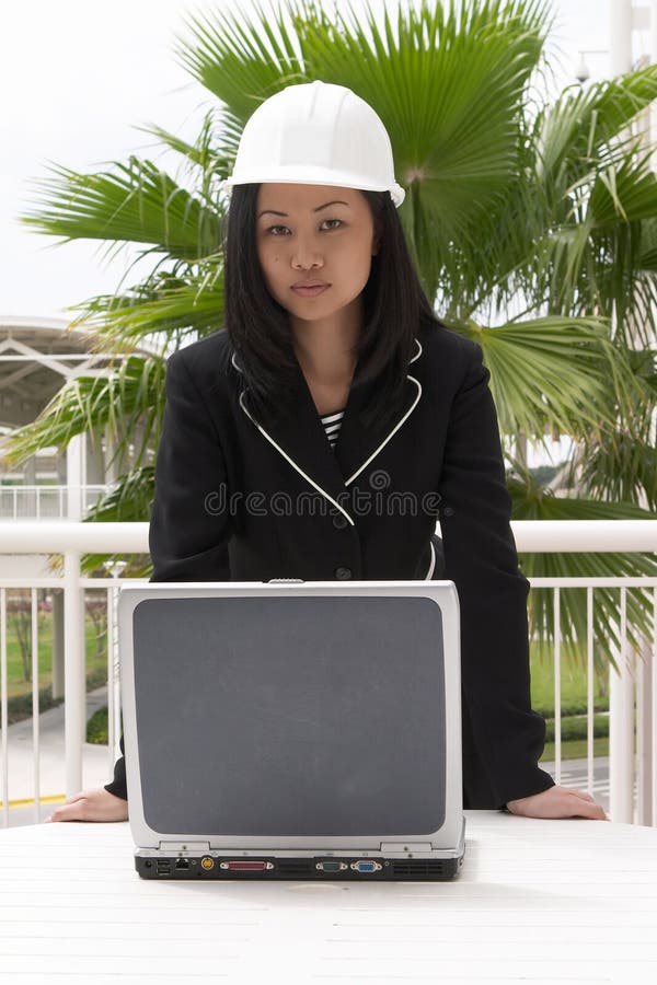 Ingeniero de sexo femenino que se coloca en la computadora portátil imagenes de archivo Ingeniero de sexo femenino que se coloca en la computadora portátil imagenes de archivo