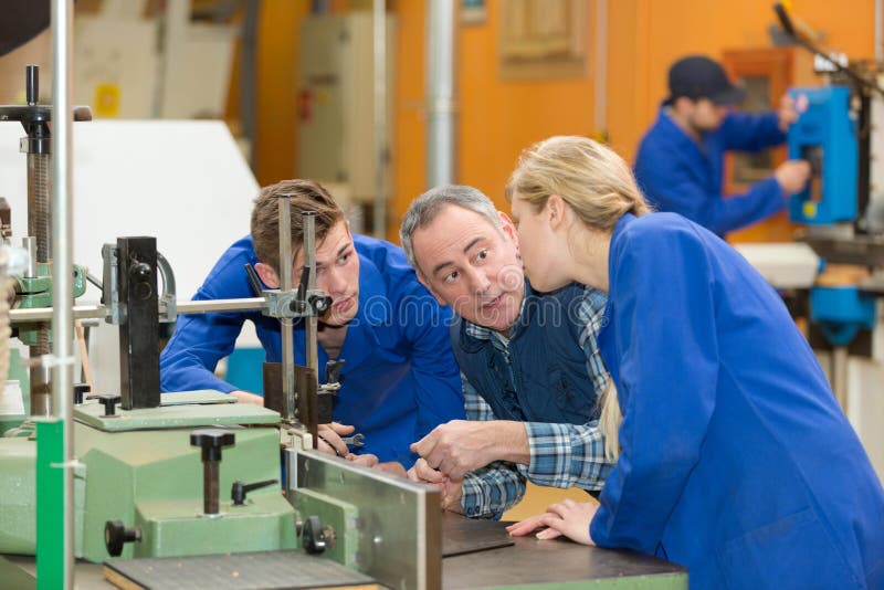Ingeniero hablando con aprendices de fábrica. Ingeniero hablando con aprendices en formación en fábricas