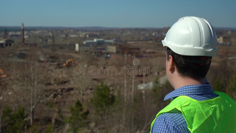 Ingeniero inspector inspecciona el territorio para la futura planta.