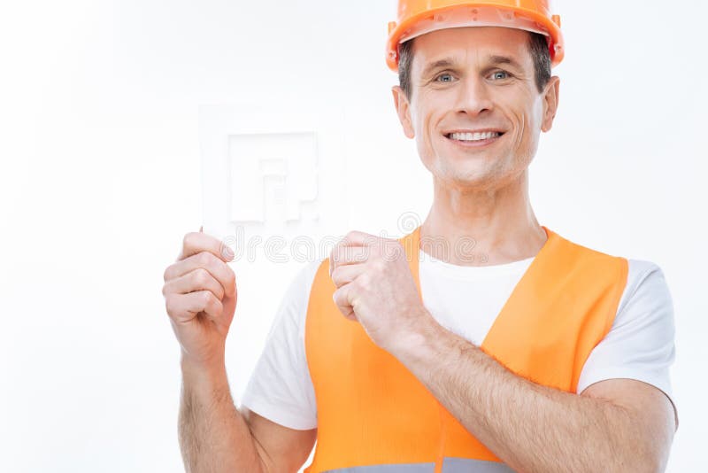 Ingeniero positivo alegre que presenta un modelo del edificio foto de archivo Ingeniero positivo alegre que presenta un modelo del edificio foto de archivo
