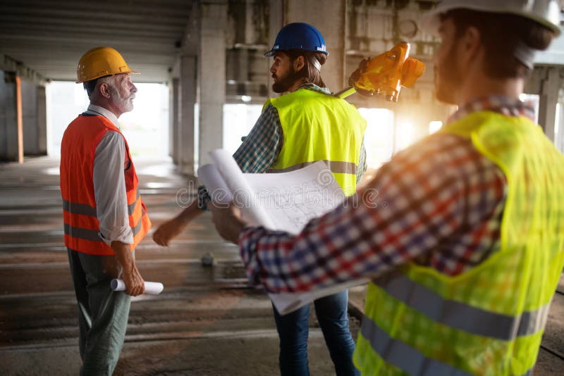 Ingeniero y administrador del sitio de la construcción que se ocupa de los modelos y de los planes imagen de archivo libre de regalías Ingeniero y administrador del sitio de la construcción que se ocupa de los modelos y de los planes imagen de archivo libre de regalías