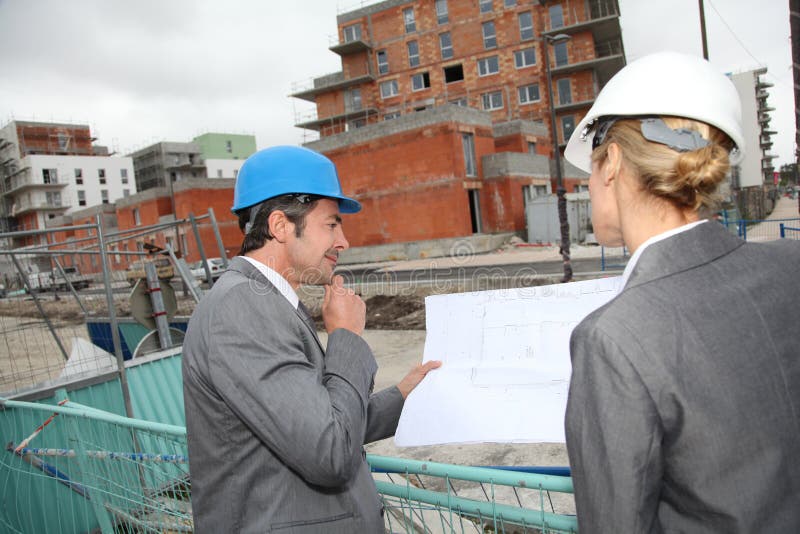 Ingenieros de construcción que trabajan con el modelo al aire libre imagenes de archivo Ingenieros de construcción que trabajan con el modelo al aire libre imagenes de archivo