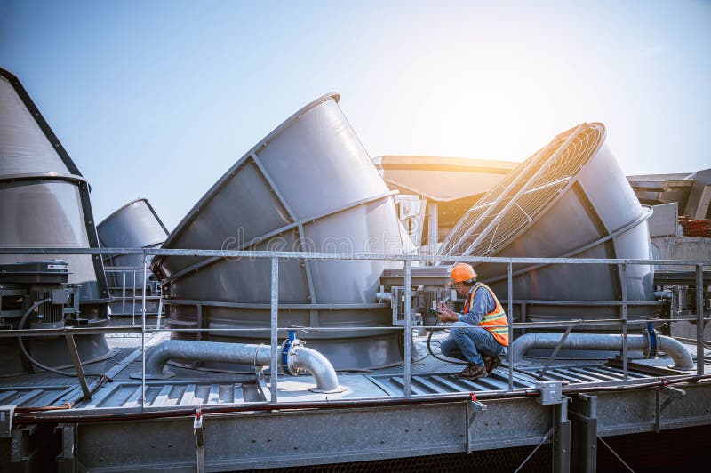 A engineer under checking the industry cooling tower air conditioner is water cooling tower air chiller HVAC of large industrial building to control air system. A engineer under checking the industry cooling tower air conditioner is water cooling tower air chiller HVAC of large industrial building to control air system.