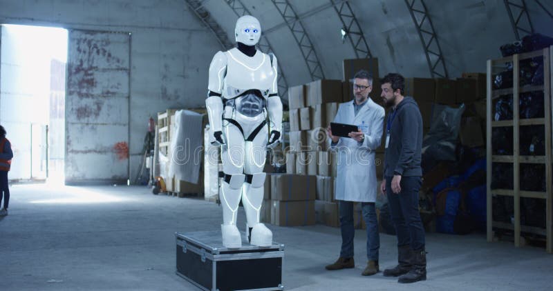 Ingenieurs die robot in een pakhuis testen royalty-vrije stock afbeeldingen Ingenieurs die robot in een pakhuis testen royalty-vrije stock afbeeldingen