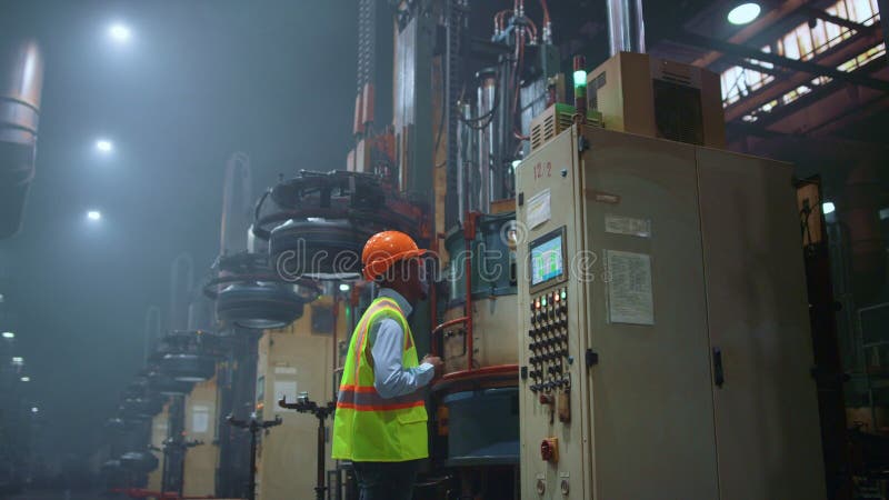 Inginer care caută o mașină modernă în imensul centru industrial profesionist. stock photography