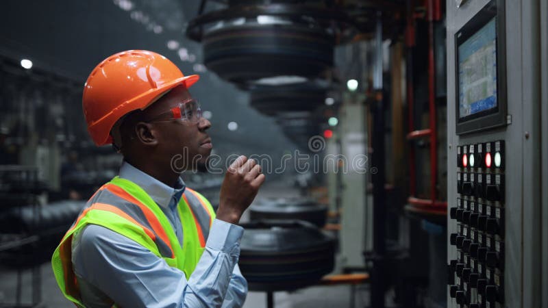Inginer de închidere care caută o masă electronică la fabrica industrială de producere a pneurilor. stock images