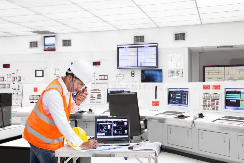 Inginer electric care lucrează în camera de control a centralei termice stock photography