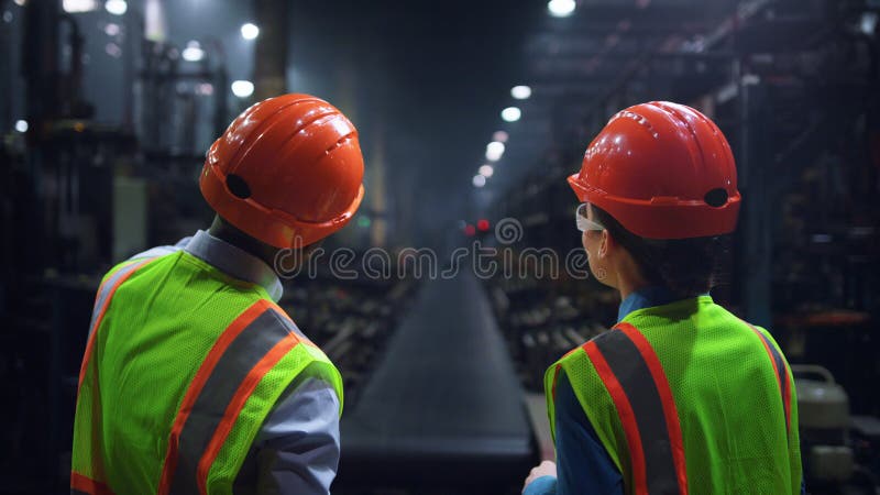Ingineri concentrați care discută despre activitatea la fabrica de anvelope de producție de energie uriașă. stock image