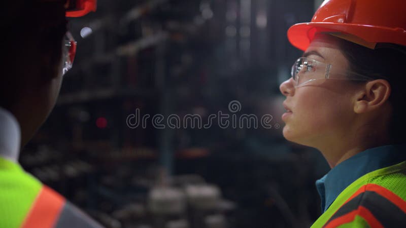 Ingineri multietnici care discută despre procesul de lucru la fabrica de pneuri. echipă zâmbitoare stock photography